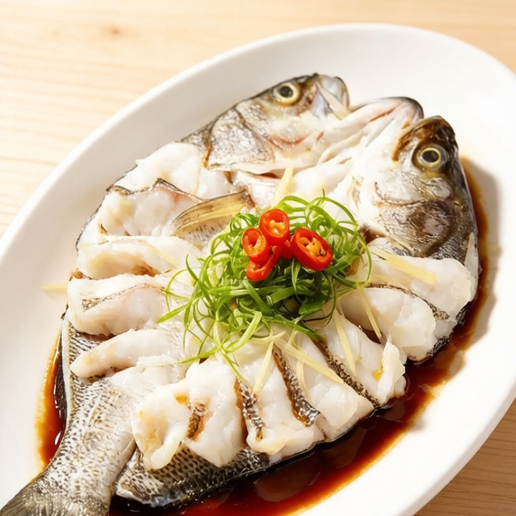 Whole back-scored sea bass steamed and topped with spring onion and red chilli